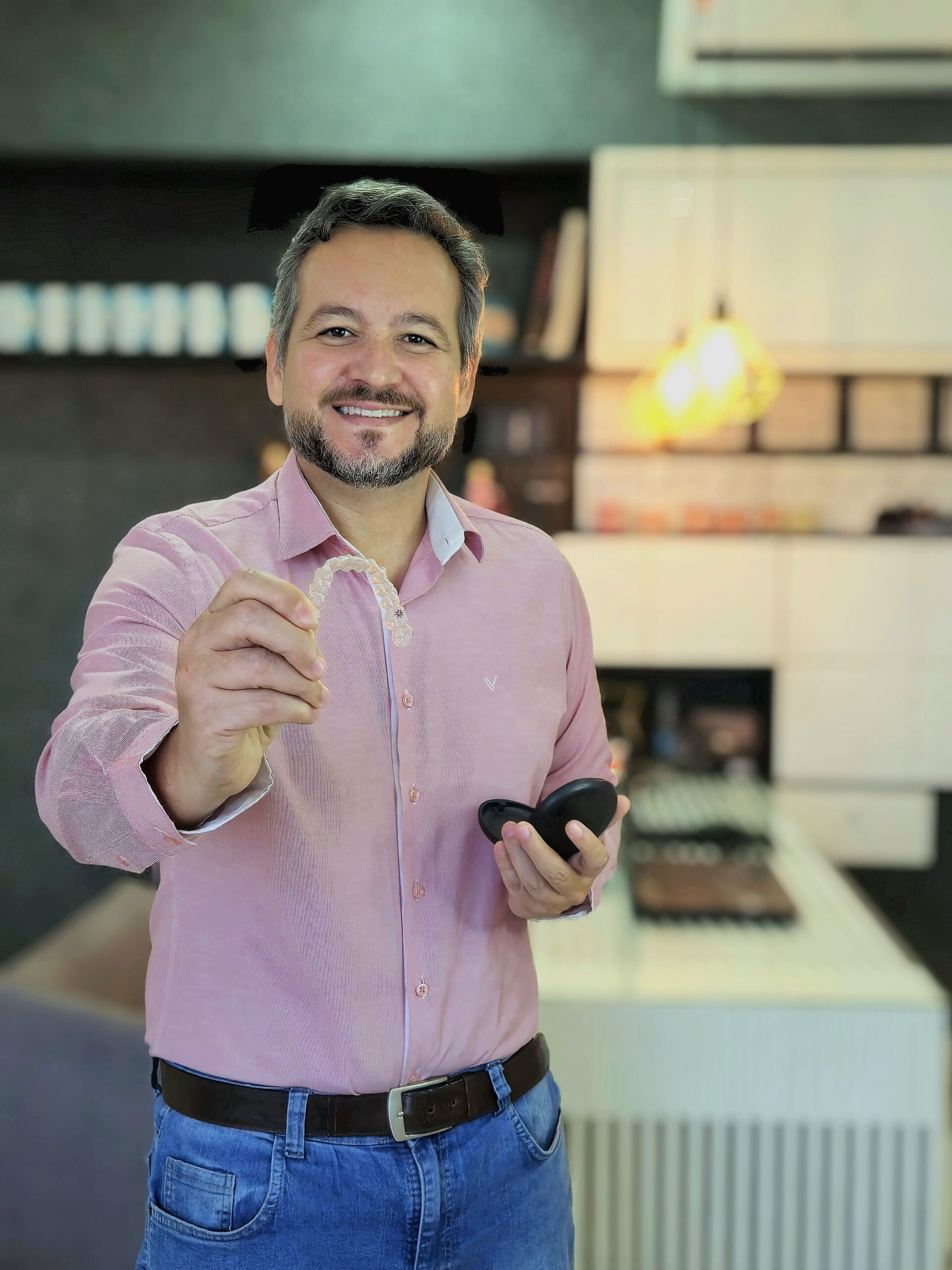 Dr. João Ribeiro segurando um alinhador Invisalign transparente